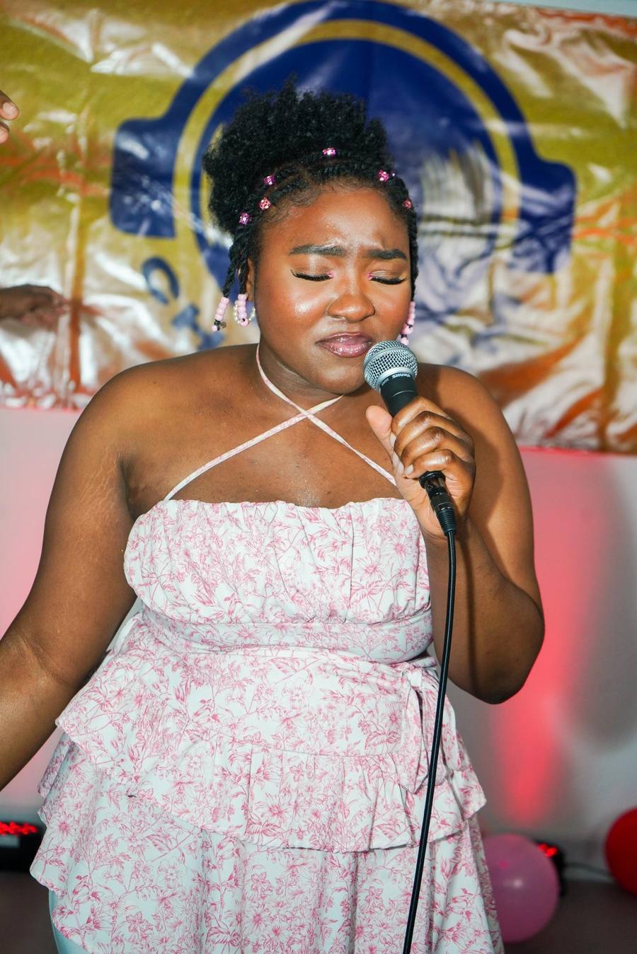 Vocalist singing into a microphone at a Christ FM event