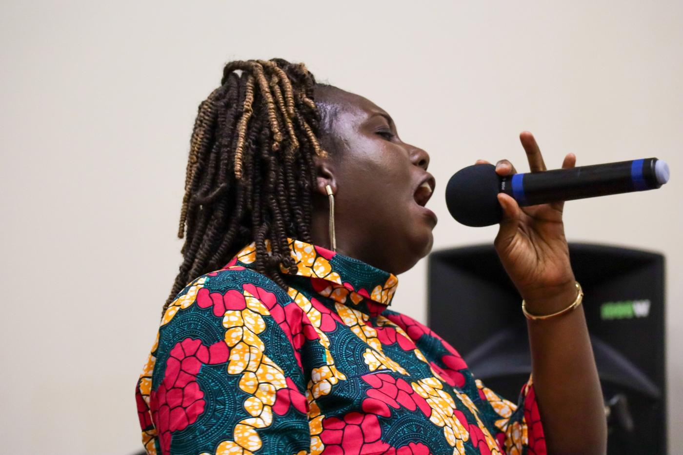 Vocalist in profile singing into a microphone