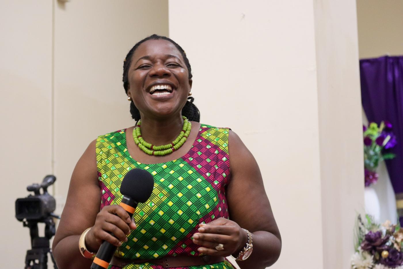 Smiling woman holding a microphone
